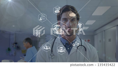 Standing mid adult doctor facing camera in hospital corridor, with stethoscope and floating icons Standing mid adult doctor facing camera in hospital corridor, with stethoscope and floating icons 135435422