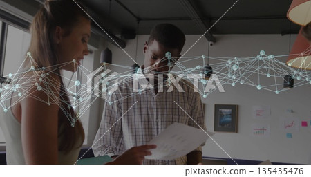 Three coworkers in checkered shirt and sleeveless top reviewing charts in office, with sticky notes 135435476