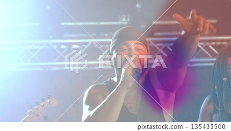 Gripping microphone, singer reaching out on stage under metal truss with lights and guitar neck Gripping microphone, singer reaching out on stage under metal truss with lights and guitar neck 135435500