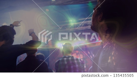 Five male concertgoers facing stage pointing in live music venue, with light truss and lens flares Five male concertgoers facing stage pointing in live music venue, with light truss and lens flares 135435505