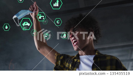 Shouting man wearing plaid shirt holding mask in industrial hall with holographic icons, copy space Shouting man wearing plaid shirt holding mask in industrial hall with holographic icons, copy space 135435519