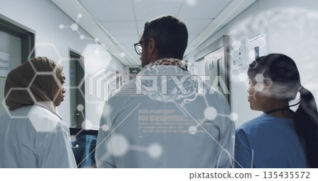 Walking trio in lab coats, hijab, scrubs in hospital corridor, with tablet scan and brain overlay 135435572