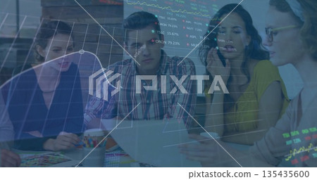 Collaborating professionals studying stock chart overlay at office meeting, with laptop Collaborating professionals studying stock chart overlay at office meeting, with laptop 135435600