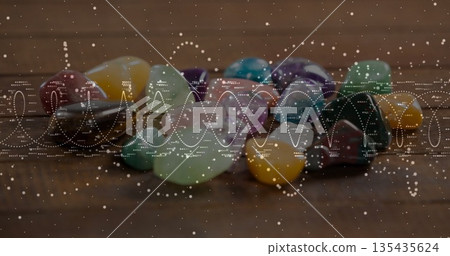 Showcasing polished gemstones sparkling on wooden tabletop in studio, with wave overlay 135435624