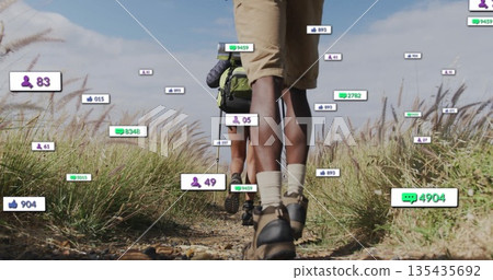 Traversing hikers carrying green and dark packs wearing boots on trail with floating notifications 135435692