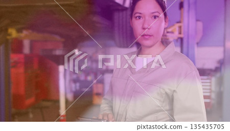 Standing mechanic in coveralls holding tablet in garage with lifts and tool cabinets, copy space 135435705