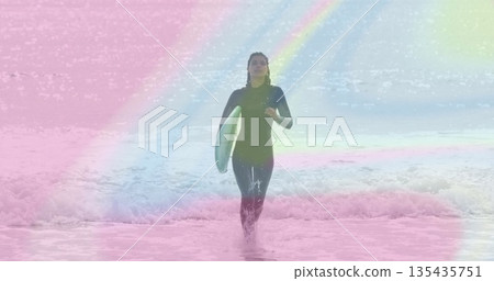 Emerging surfer in wetsuit striding through waves at beach, carrying turquoise surfboard, pastels 135435751