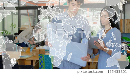 Reviewing blueprint and tablet, man and woman colleagues in shirt and dress collaborating in office Reviewing blueprint and tablet, man and woman colleagues in shirt and dress collaborating in office 135435801