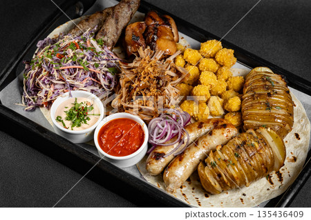 Delicious grilled meat platter with various sauces served on a wooden board, perfect for sharing with friends and family Delicious grilled meat platter with various sauces served on a wooden board, perfect for sharing with friends and family 135436409
