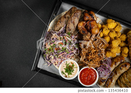 Delicious grilled meat platter with various sauces served on a wooden board, perfect for sharing with friends and family Delicious grilled meat platter with various sauces served on a wooden board, perfect for sharing with friends and family 135436410