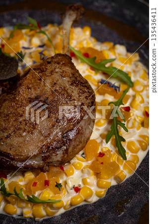 Duck leg with risotto, pumpkin and herbs on a dark background Duck leg with risotto, pumpkin and herbs on a dark background 135436411