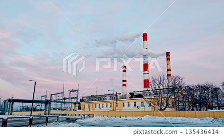 urban thermal power plant in the evening, a thermal power plant with cooling towers producing energy during Winter and cold months. Pink, purple clouds urban thermal power plant in the evening, a thermal power plant with cooling towers producing energy during Winter and cold months. Pink, purple clouds 135436414