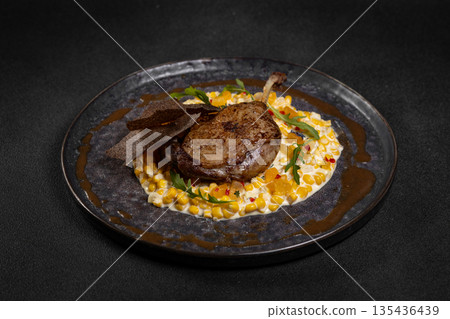 Duck leg with risotto, pumpkin and herbs on a dark background Duck leg with risotto, pumpkin and herbs on a dark background 135436439