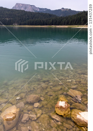 Vertical landscape photo featuring coastal stones of a lake 135437289