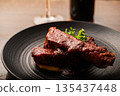 Spare ribs served on a black plate 135437448