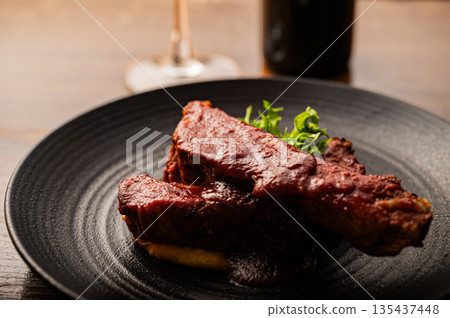 Spare ribs served on a black plate Spare ribs served on a black plate 135437448