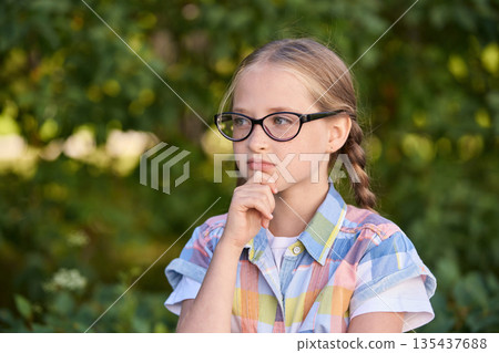 Thoughtful caucasian young girl with glasses in outdoor natural setting Thoughtful caucasian young girl with glasses in outdoor natural setting 135437688