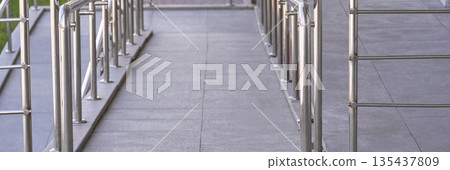 Modern accessible entrance with metal railings and concrete ramp for easy 135437809