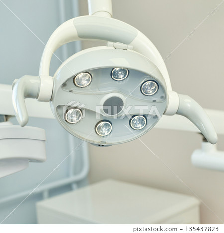 Modern dental operating light in clinic setting with white and silver design Modern dental operating light in clinic setting with white and silver design 135437823