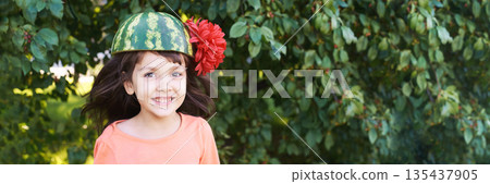 Joyful caucasian young girl wearing watermelon hat and red flower outdoors Joyful caucasian young girl wearing watermelon hat and red flower outdoors 135437905
