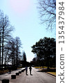 人們在冬日的公園散步，周圍是樹木。 135437984