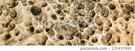 Natural eroded rock surface with unique patterns and textures in earthy tones Natural eroded rock surface with unique patterns and textures in earthy tones 135437995