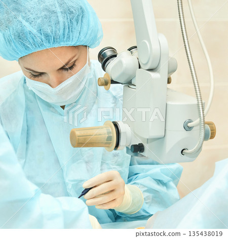 Female surgeon performing microsurgery with precision in operating room Female surgeon performing microsurgery with precision in operating room 135438019