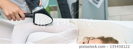 Female undergoing laser hair removal treatment on legs in medical clinic Female undergoing laser hair removal treatment on legs in medical clinic 135438122