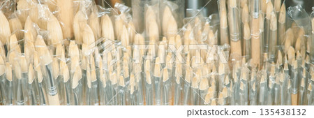 Close-up of multiple wooden art brushes with transparent plastic covers Close-up of multiple wooden art brushes with transparent plastic covers 135438132