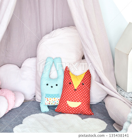 Cozy childrens playroom with cute handmade plush toys on floor in soft tent 135438141
