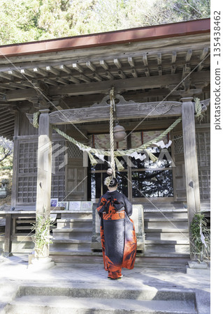 A woman in a kimono praying at a shrine 135438462