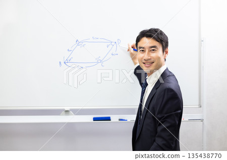 Smiling cram school teacher using a whiteboard to teach math Smiling cram school teacher using a whiteboard to teach math 135438770
