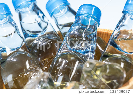 一瓶裝有彈珠的玻璃瓶裝彈珠，放在裝滿冰塊的木桶裡。 135439027