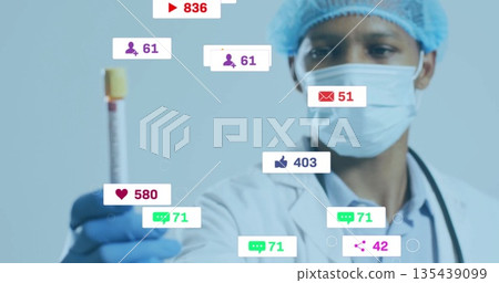 Holding capped blood tube with stethoscope, showing social media alerts in clinical lab, copy space 135439099