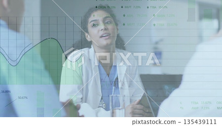 Doctor with stethoscope reviewing data with team in hospital meeting room, with laptop, water glass Doctor with stethoscope reviewing data with team in hospital meeting room, with laptop, water glass 135439111
