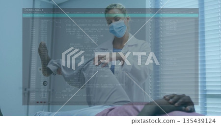 Bending female physician gently examining patient's knee in clinic exam room, with code overlay 135439124