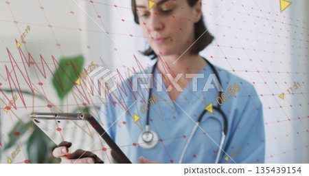 Holding tablet, clinician wearing scrubs stethoscope viewing overlays near potted plant in clinic Holding tablet, clinician wearing scrubs stethoscope viewing overlays near potted plant in clinic 135439154