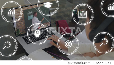 Watching Asian teenager typing notes viewing lecture at desk with laptop and sweatshirt, copy space 135439235