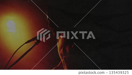 Performing shirtless male vocalist singing on club stage, with microphone and glowing stage light Performing shirtless male vocalist singing on club stage, with microphone and glowing stage light 135439325
