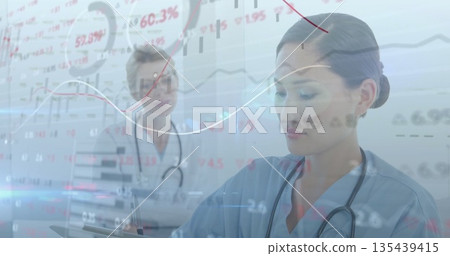 Writing Asian nurse in blue scrubs with lab-coated doctor in exam room, charts overlay, copy space 135439415