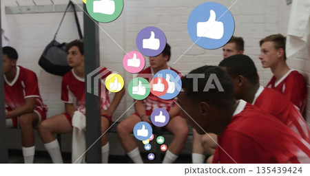 Sitting teenage soccer players wearing red jerseys on bench in locker room, with floating thumbs up Sitting teenage soccer players wearing red jerseys on bench in locker room, with floating thumbs up 135439424