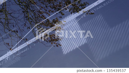 Displaying glass window reflecting autumn leaves and code overlay in office, with blinds shadows Displaying glass window reflecting autumn leaves and code overlay in office, with blinds shadows 135439537