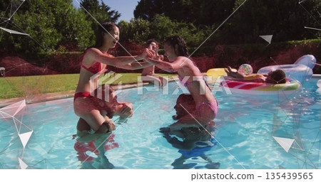 Laughing friends playing chicken-fight matches in backyard pool with bikinis, trunks and beach ball Laughing friends playing chicken-fight matches in backyard pool with bikinis, trunks and beach ball 135439565