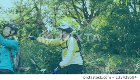 Pausing cyclists on mountain bikes wearing jackets and helmets on forest trail, with math equations 135439594