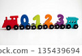 Colorful wooden number train with locomotive and passenger car sits on a white surface 135439694