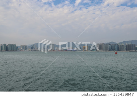 Dec 31 2025 East Victoria Harbour waterfront promenade under urban skyline Dec 31 2025 East Victoria Harbour waterfront promenade under urban skyline 135439947