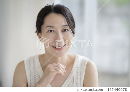 一個 50 多歲的女人的美麗形象肖像，她微笑著看著相機 135440078