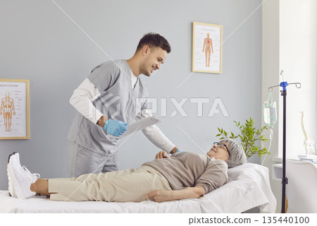 Sick senior patient lying on the couch in hospital receiving IV drip infusion. Sick senior patient lying on the couch in hospital receiving IV drip infusion. 135440100