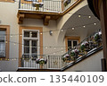 Cozy courtyard with string lights and flower pots during winter season with snow on the ground 135440109
