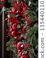 Festive red and green holiday wreath with ornaments and ribbons, close-up view with copy space 135440110